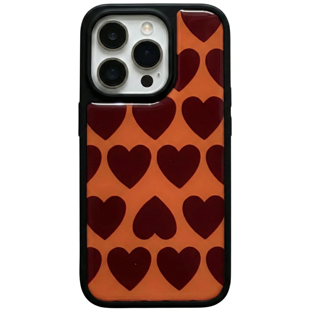 Glossy iPhone case featuring a retro dark red repeating heart pattern on an orange background with a protective black rubber bumper.